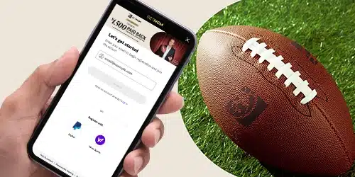 BetMGM sign up banner for WestVirginiaBettingHub with a hand holding a mobile phone showing the sign up page of the BetMGM mobile app, next to an NFL ball